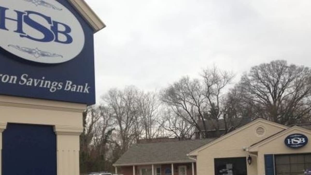 High school graduate in cap and gown holding diploma on Maryland's Eastern Shore