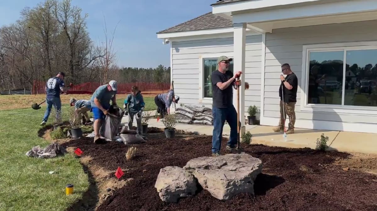 Volunteers working on landscaping around single-story accessible home for wounded Army veteran in Virginia
