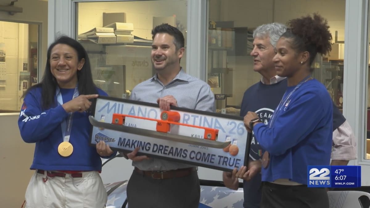 Olympic bobsledders Elana Meyers Taylor and Jasmine Jones standing with factory workers at Advance Manufacturing