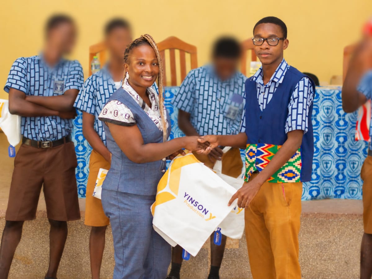 High school students in Ghana collaborating on entrepreneurship project presentations in classroom setting