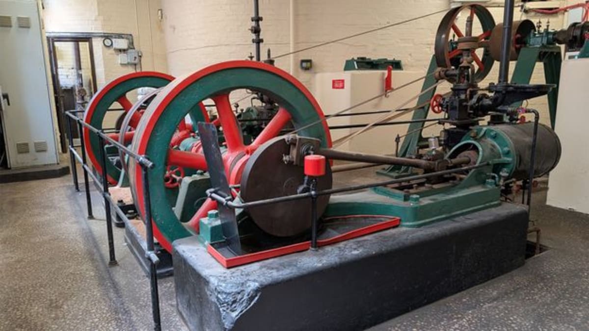 Historic red six-blade industrial fan set in brick wall at Belfast hospital