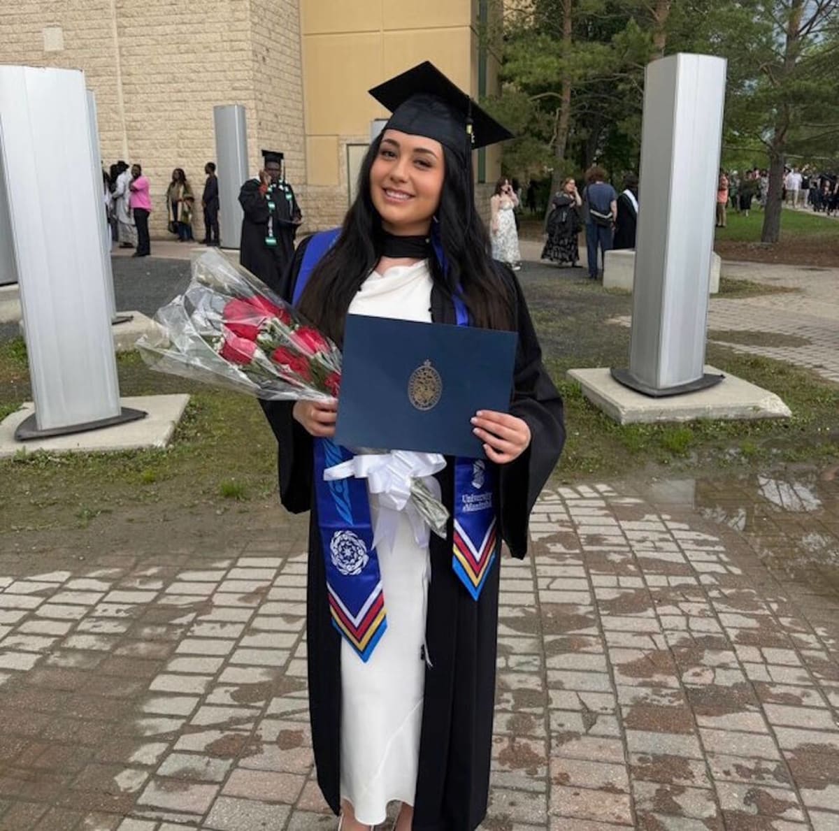 Mae Himngaat Mercer Manik smiling in graduation attire after earning her bachelor's degree