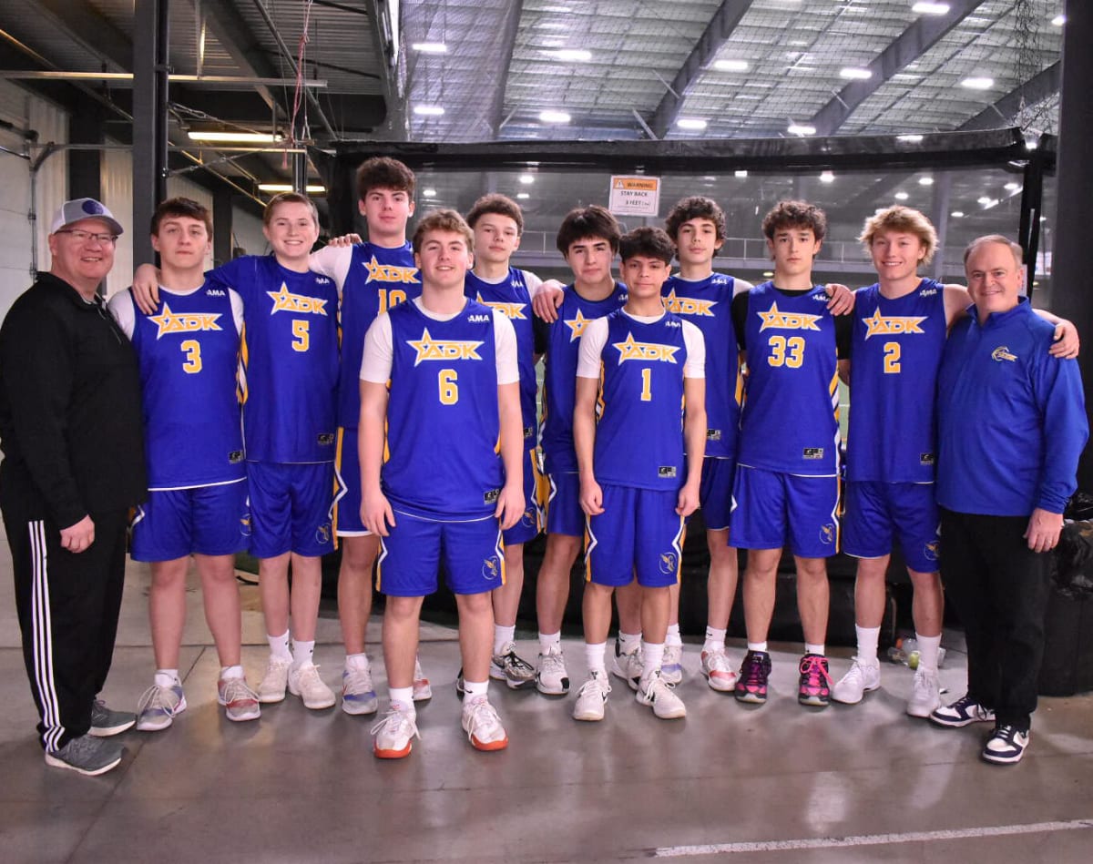 ADK NorthStars youth basketball team poses with coaches holding championship trophy in New York