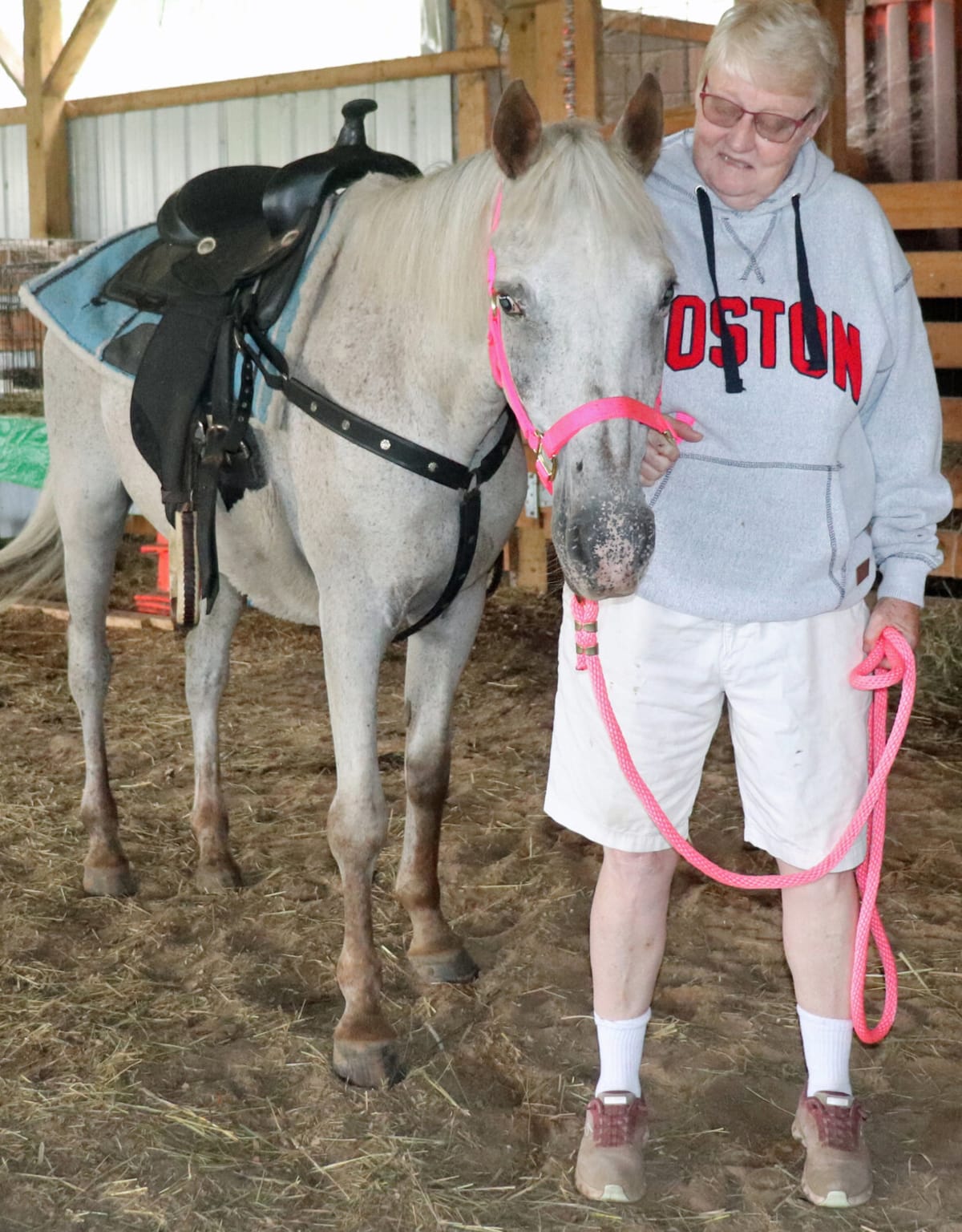 ** Karla Trimm standing beside Hazel, a brown and white Appaloosa horse at K-Stone Rescue ranch