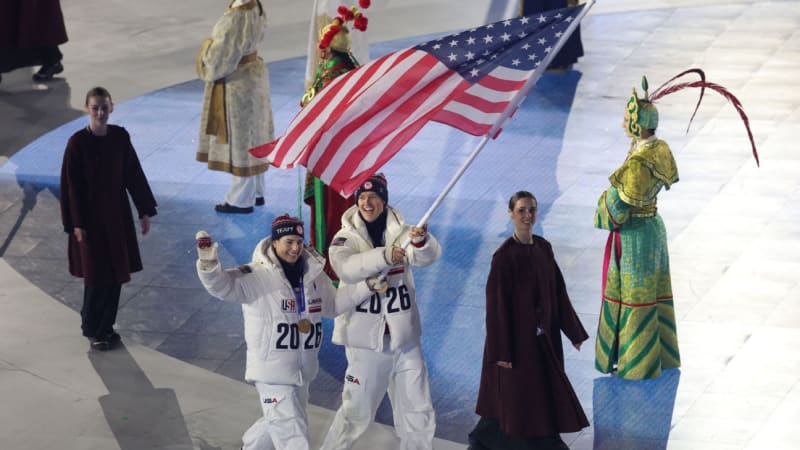 Athletes celebrating with Italian flags during closing ceremony in historic Verona Arena amphitheater