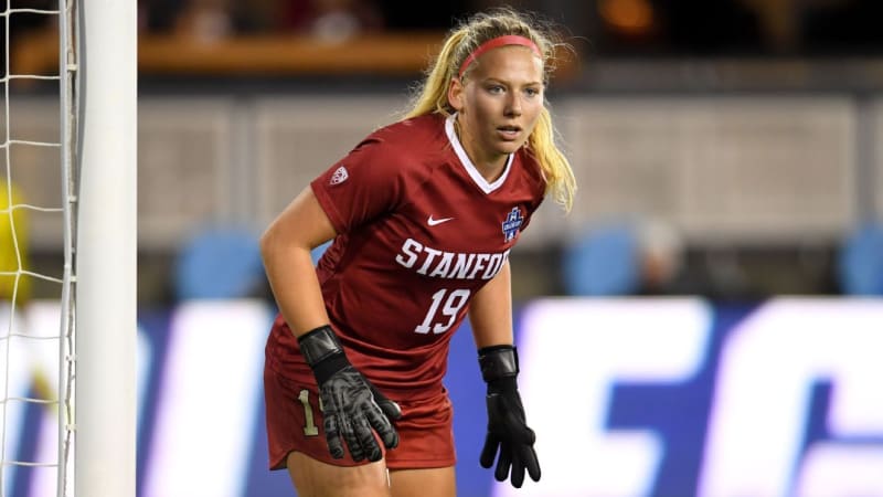 Katie Meyer in Stanford soccer goalkeeper uniform celebrating on field with teammates