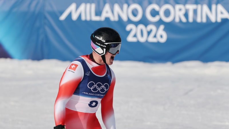 Franjo von Allmen celebrates on Olympic podium wearing gold medal and Swiss team gear