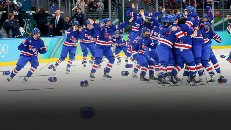 U.S. women's hockey team celebrating Olympic gold medal victory on ice in Milan