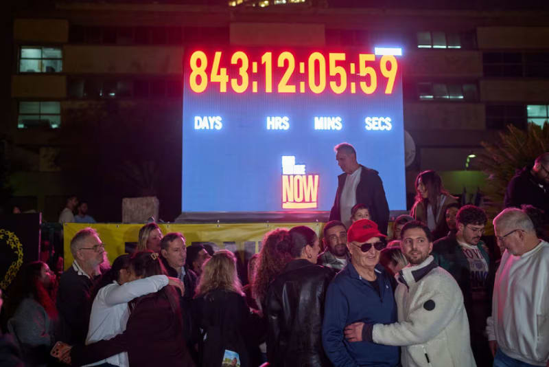 Crowd gathers around digital clock display at Hostages Square in Tel Aviv