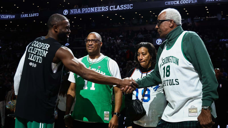 Families of NBA pioneers Chuck Cooper, Earl Lloyd, and Nat Clifton at center court during inaugural Pioneers Classic