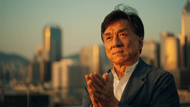 Jackie Chan smiling at event representing his charitable work and legacy