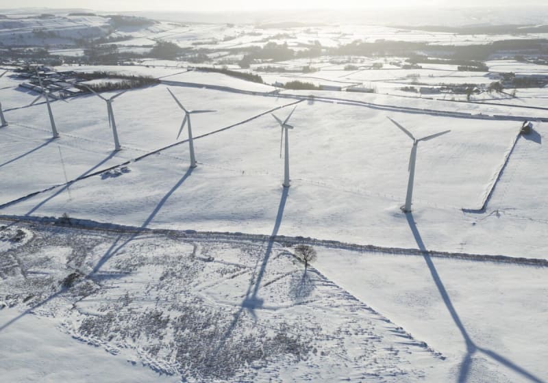 Wind turbines spinning across green Yorkshire hills under cloudy British sky