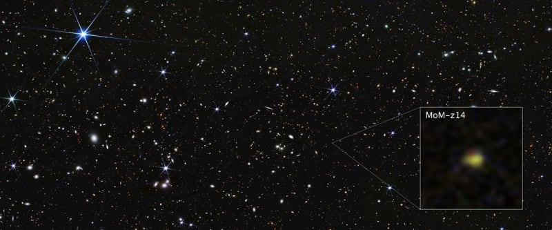 James Webb Space Telescope image showing distant galaxy MoM-z14 glowing in deep space