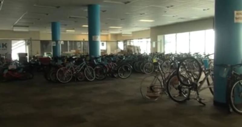 Volunteers repairing donated bicycles at indoor workspace for children's bike donation program