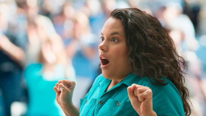 Couple embracing in urgent care clinic as medical staff celebrates engagement proposal