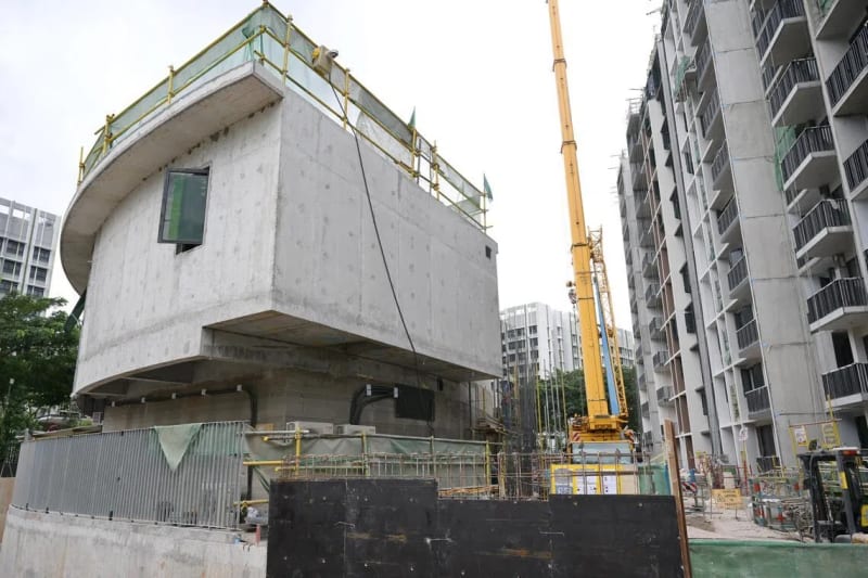 Large robotic 3D printer building curved concrete walls at Singapore construction site