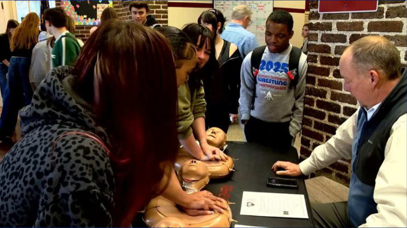 Students practicing chest compressions on CPR training mannequins during Duke University's statewide training event
