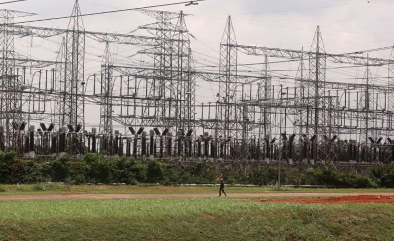 Electrical transmission towers connecting power grids across West African nations under blue sky