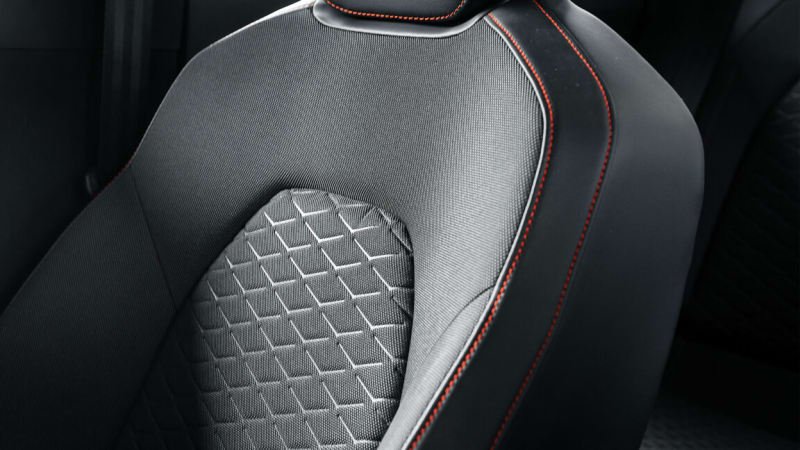 Modern luxury car interior featuring sustainable fabric seats in neutral tones with elegant stitching
