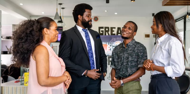 Nigerian entrepreneurs collaborating on laptops, celebrating business growth and digital success through online platforms