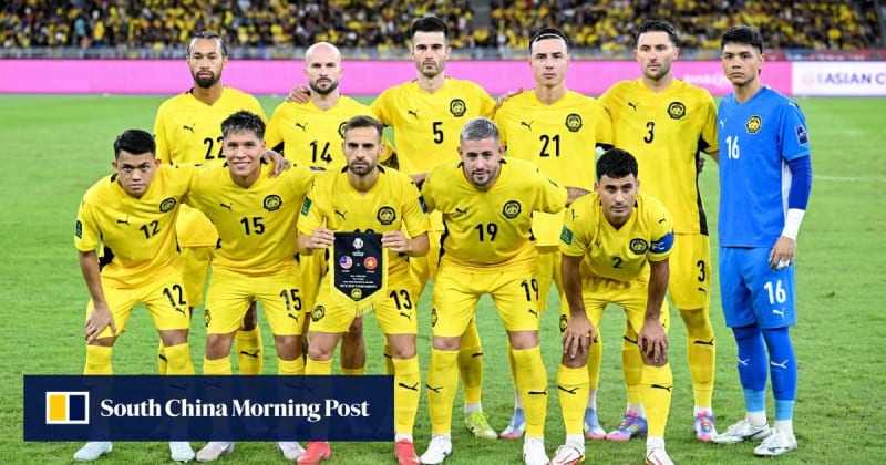 Malaysian national football team players celebrating on field during international match competition