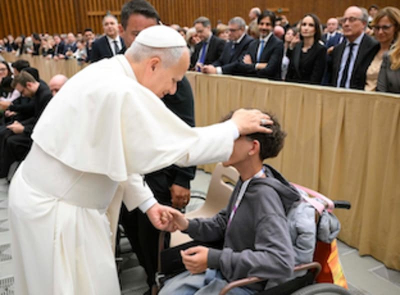 Pope Leo XIV gesturing warmly while delivering a message about compassion and caring for the sick