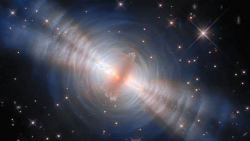 Hubble telescope image showing the Egg Nebula with twin light beams and rippling arcs of dust