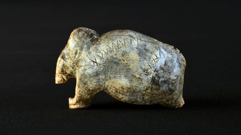 Ancient ivory mammoth figurine with carved sequences of crosses and dots from 40,000 years ago