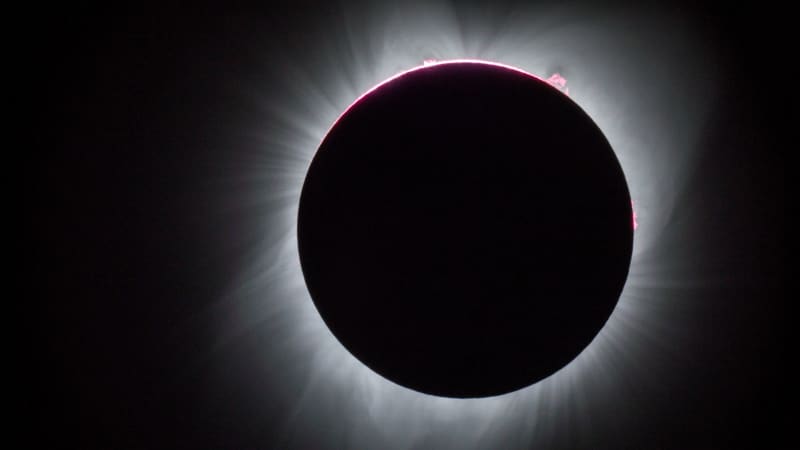 Total solar eclipse showing the sun's corona glowing around the moon's dark silhouette
