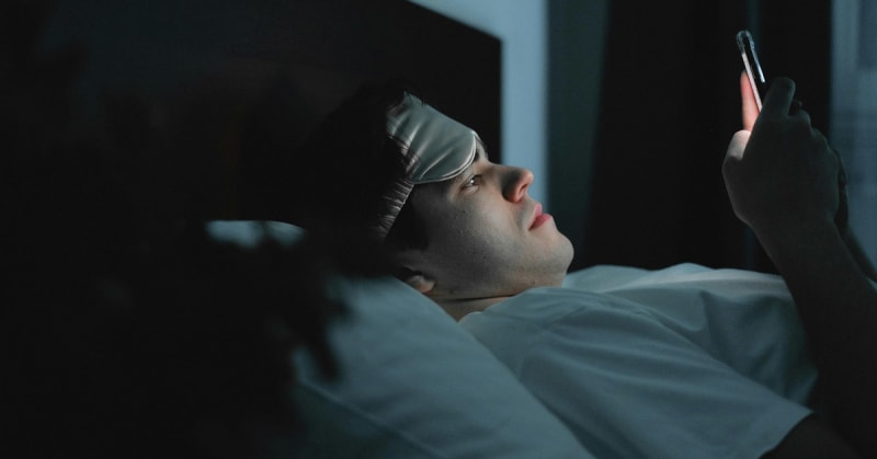 Person relaxing outdoors without phone, looking peaceful in natural setting with trees