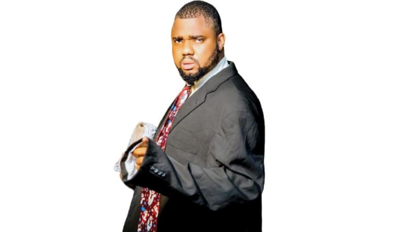 Nigerian comedian Femi Babs smiling while creating inspirational content for social media