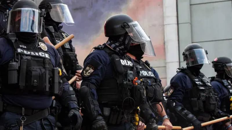 Nigerian police officers in professional gear conducting safety operations in a community setting, demonstrating public protection protocols