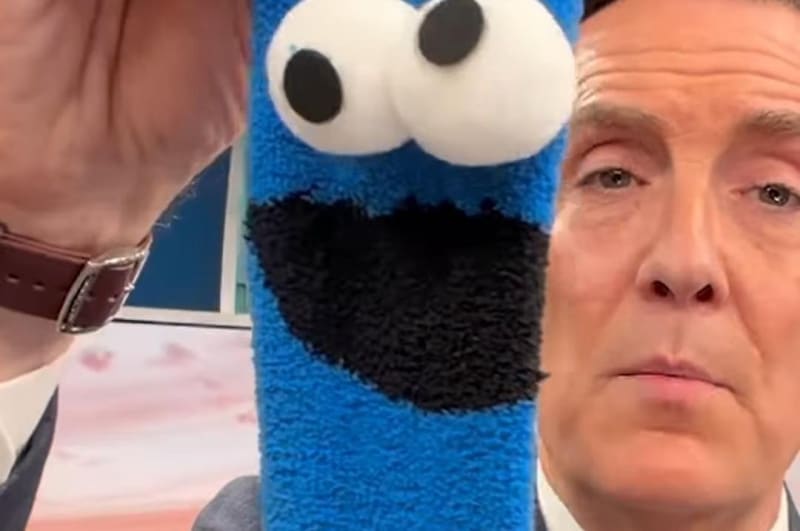 Retired CBS Philadelphia news anchor Jim Donovan smiling with colorful sock collection displayed around him