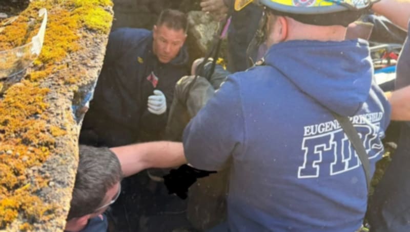 Firefighters performing technical rescue operation along concrete river diversion wall in Eugene, Oregon