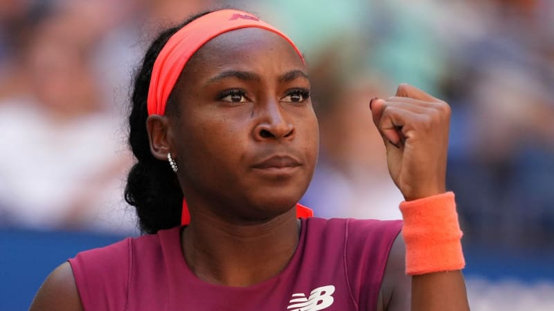 Tennis player Coco Gauff preparing to serve during a professional match at a Grand Slam tournament