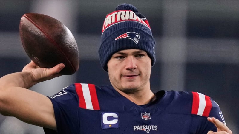Drake Maye throwing football during Patriots playoff game in New England stadium