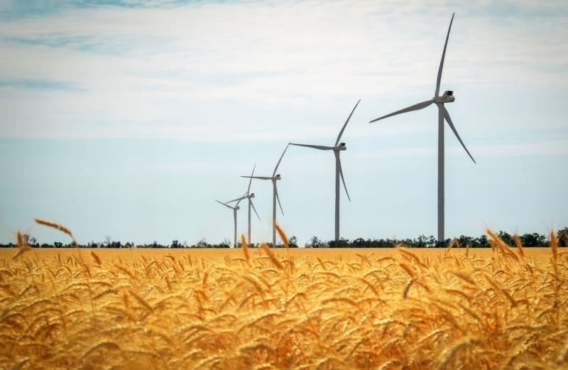 Modern wind turbines spinning against blue sky generating clean renewable electricity in northern Germany