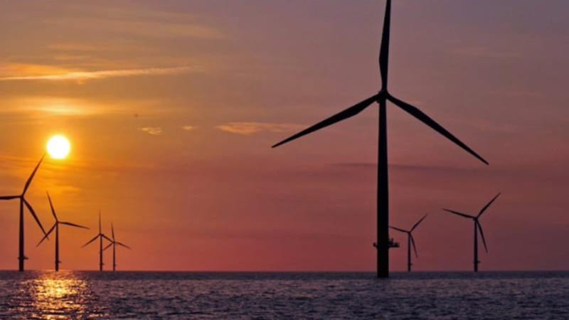 ** Offshore wind turbines rising from Baltic Sea waters under blue sky