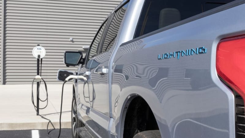 Row of used electric vehicles parked at dealership lot ready for affordable purchase