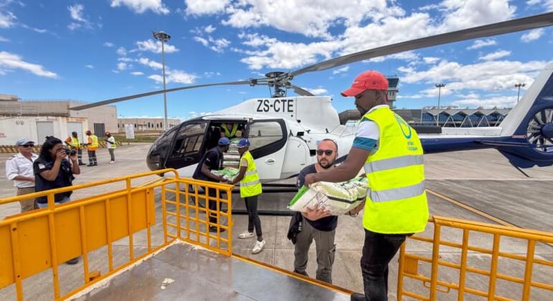 UN aid workers unloading relief supplies from trucks in a disaster zone