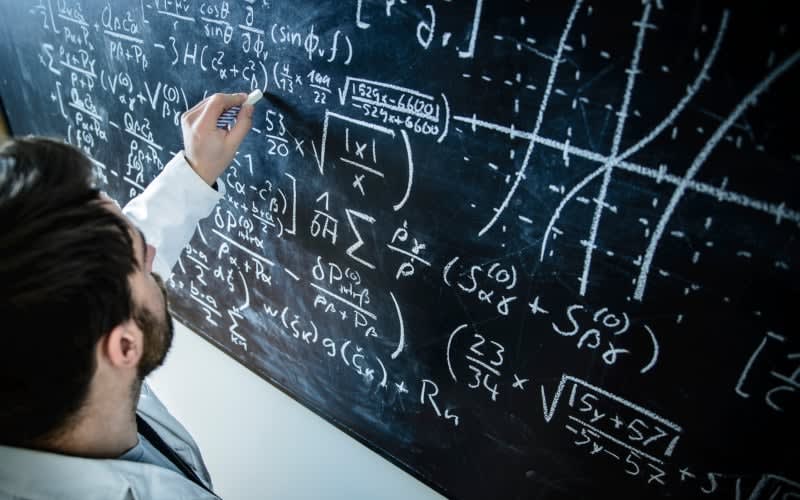 Teenage student working on mathematics problems in classroom with confidence and focus