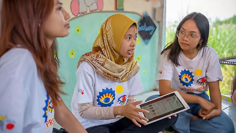 Indonesian woman learning digital marketing skills on laptop computer at home workspace