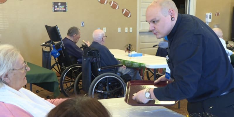 Activity director Taylor Garcia serving refreshments to smiling seniors at nursing home sing-along event