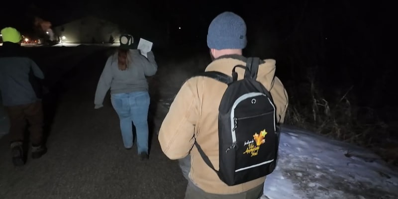 Volunteers with clipboards conducting nighttime homeless count survey in Eau Claire Wisconsin streets