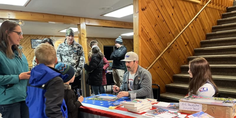 Olympic gold medalist Nick Baumgartner smiling with young fans at Ski Brule resort in Michigan