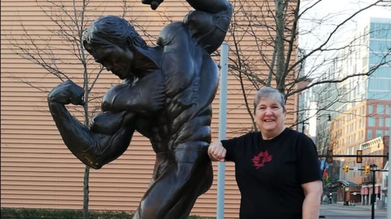 Jeanine Watt, 69-year-old powerlifter, posing with weightlifting equipment in gym