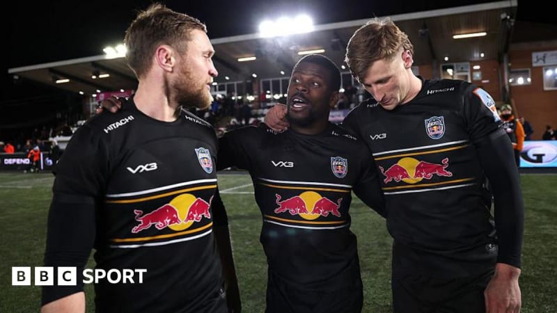 Newcastle Red Bulls rugby players celebrating together on the pitch after their historic victory over Gloucester