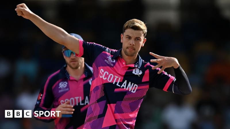 Scotland cricket team players celebrating on field wearing blue jerseys during international match