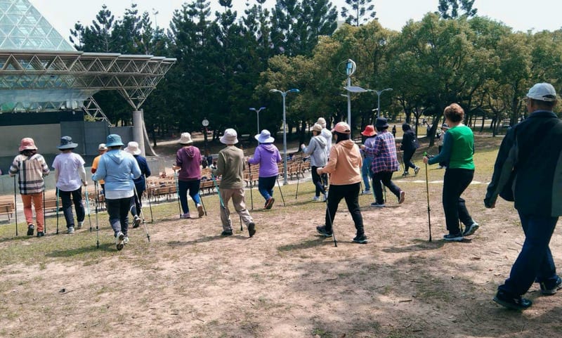 Senior adult walking outdoors on sunny path demonstrating exercise therapy for Parkinson's disease