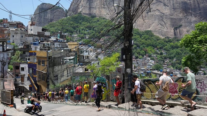 Tour guide showing international tourists scenic viewpoint overlooking Rio de Janeiro from Rocinha favela
